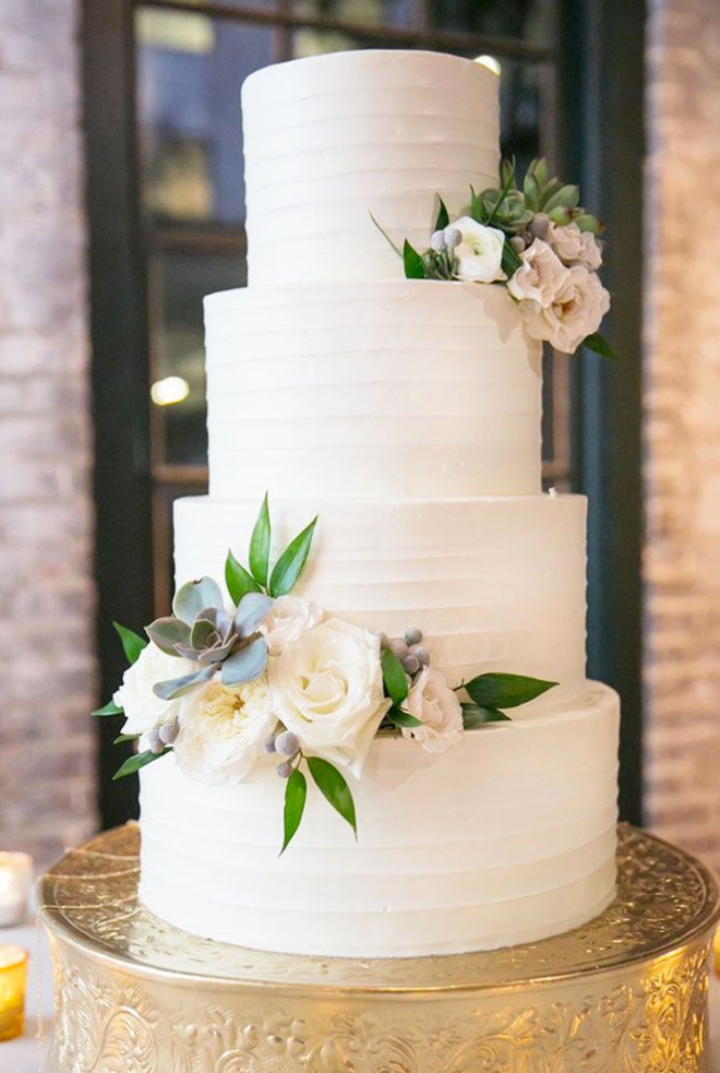 Kue ulang tahun bertingkat dengan buttercream dan bunga segar